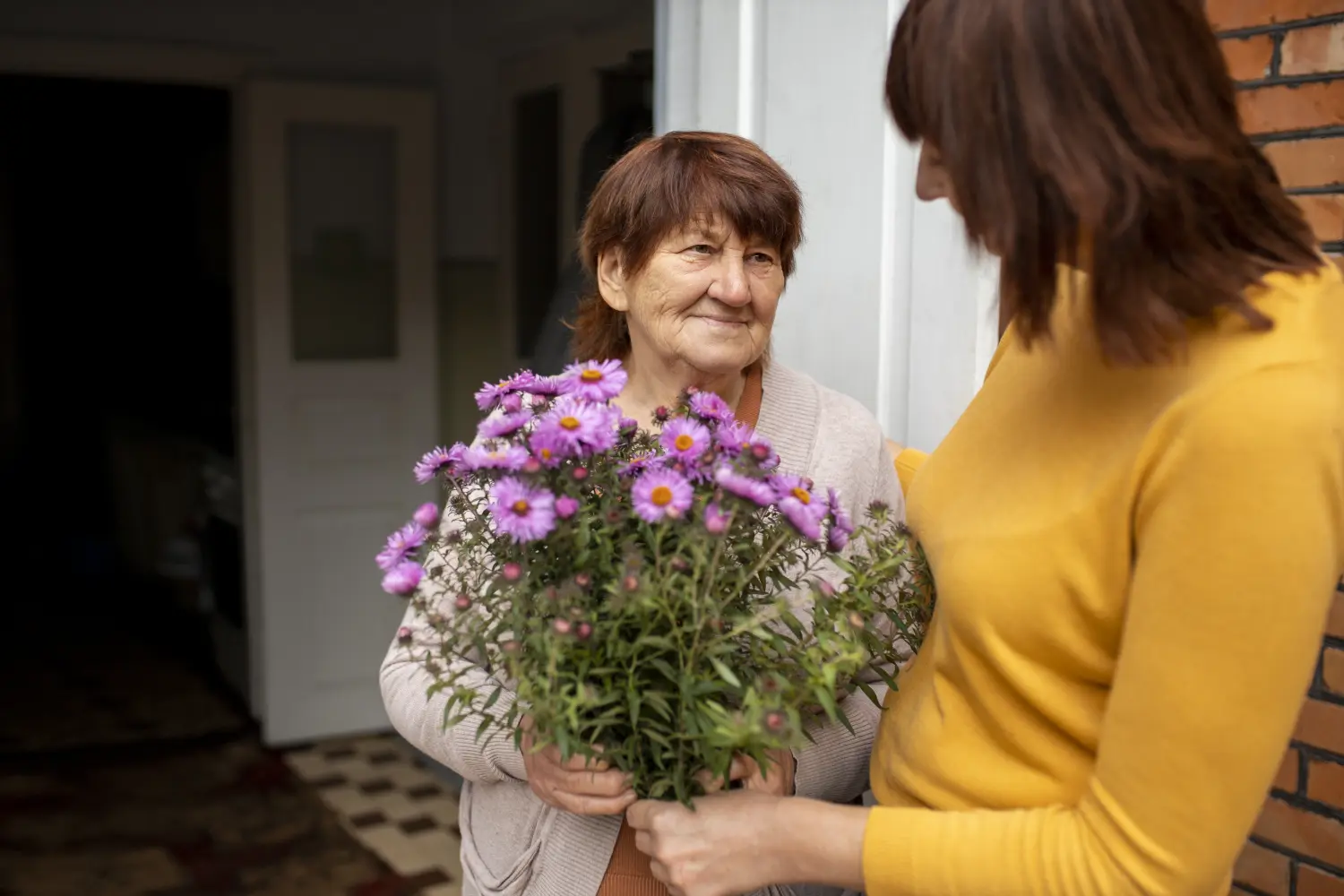 In Guten Händen - Frau schenkt einer alten Dame Blumen
